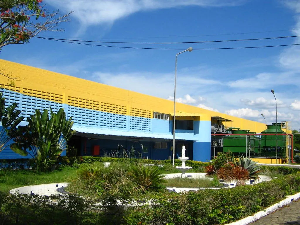 Facciata della fabbrica Necttare, con prato e cielo azzurro